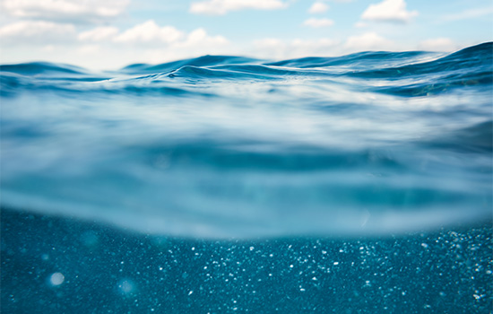 Zdjęcie z fal oceanu z błękitnym niebem, zrobione z wnętrza wody